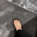 Foot pressing down on flooded carpet with water seeping up